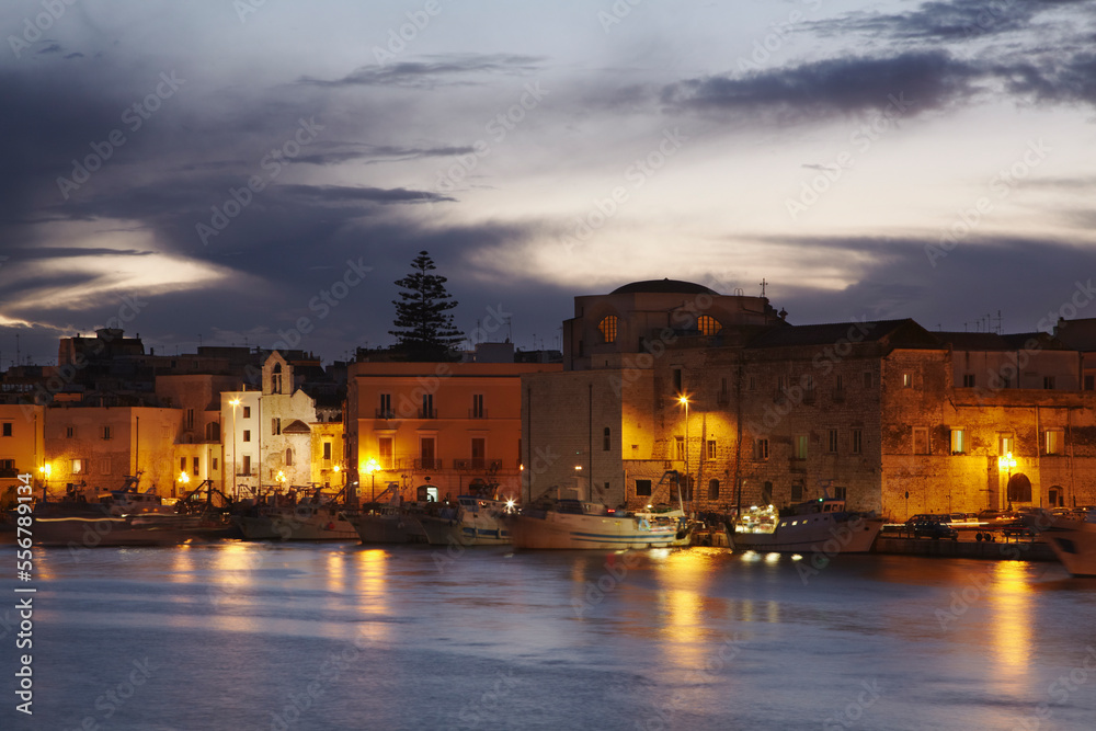 A dusk view of the fishing boats in the harbor of Trani.; Trani, Puglia, Italy. A dusk view of the fishing boats in the harbor of Trani.; Trani, Puglia, Italy.