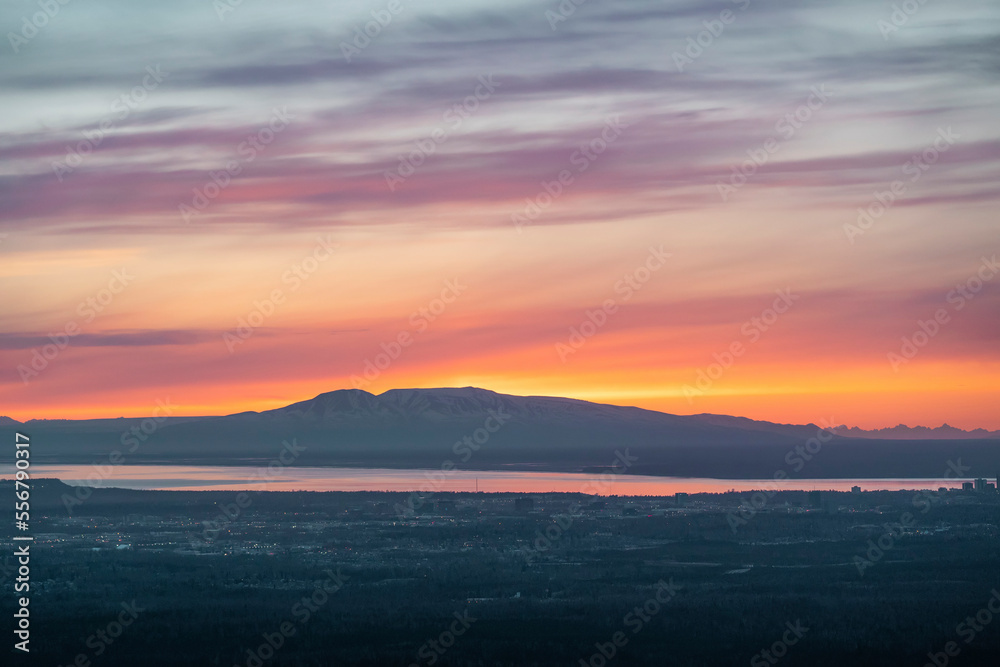 The sun sets above Mt. Susitna, or Sleeping Lady, across Cook Inlet from downtown Anchorage, Alaska on Dena’ina land, with Knik arm in view; Alaska, United States of America The sun sets above Mt. Susitna, or Sleeping Lady, across Cook Inlet from downtown Anchorage, Alaska on Dena’ina land, with Knik arm in view; Alaska, United States of America