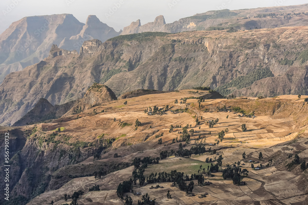 Scenic view of jagged mountain peaks with patchwork farmland on a plateau in the Simen Mountains in Northern Ethiopia; Simien Mountains National Park, Ethiopia Scenic view of jagged mountain peaks with patchwork farmland on a plateau in the Simen Mountains in Northern Ethiopia; Simien Mountains National Park, Ethiopia