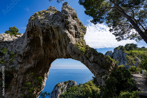 View through the Arco Naturale, a Palaeolithic era limestone arch, remains of a collapsed grotto, 18m high, span of 12m, on the east coast of the Island of Capri; Naples, Capri, Italy photo