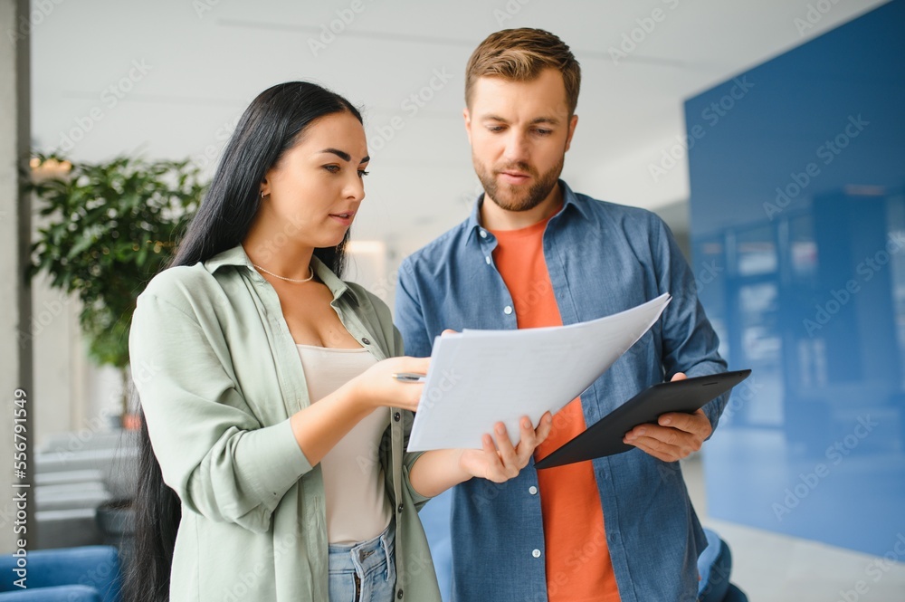 Two business coworkers walking through a lobby of an office building Two business coworkers walking through a lobby of an office building