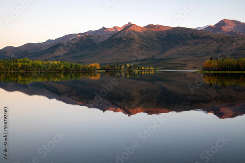 Scenic view of the mountains of Denali National Park and the fall colored trees reflected in Otto Lake near Healy; Interior Alaska, Alaska, United States of America photo