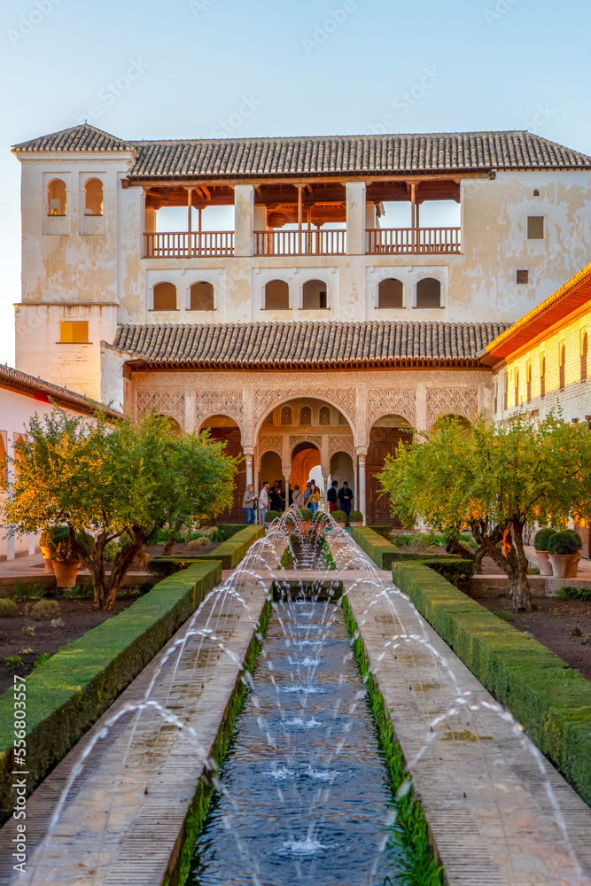 Fototapeta premium Fountain in green gardens of ancient Alhambra in Granada, Spain on November 26, 2022 