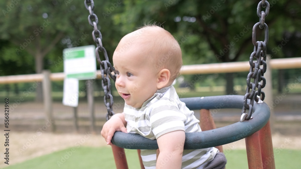 Funny Little Younger Newborn Infant Brother Boy On Swing. Baby Playing On Playground. Summer time outside. Kids Entertainment, Childhood, Child Development, Happy Family Concept Funny Little Younger Newborn Infant Brother Boy On Swing. Baby Playing On Playground. Summer time outside. Kids Entertainment, Childhood, Child Development, Happy Family Concept