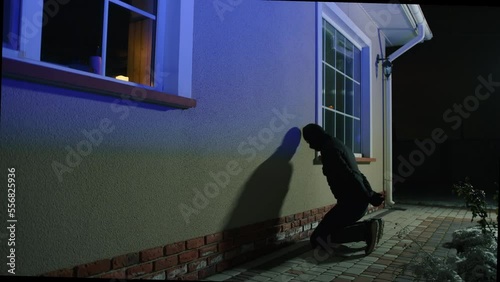 A captured criminal is waiting to be handcuffed with hands behind his back. Close-up view of a burglar kneels for arrest. High quality 4k footage
