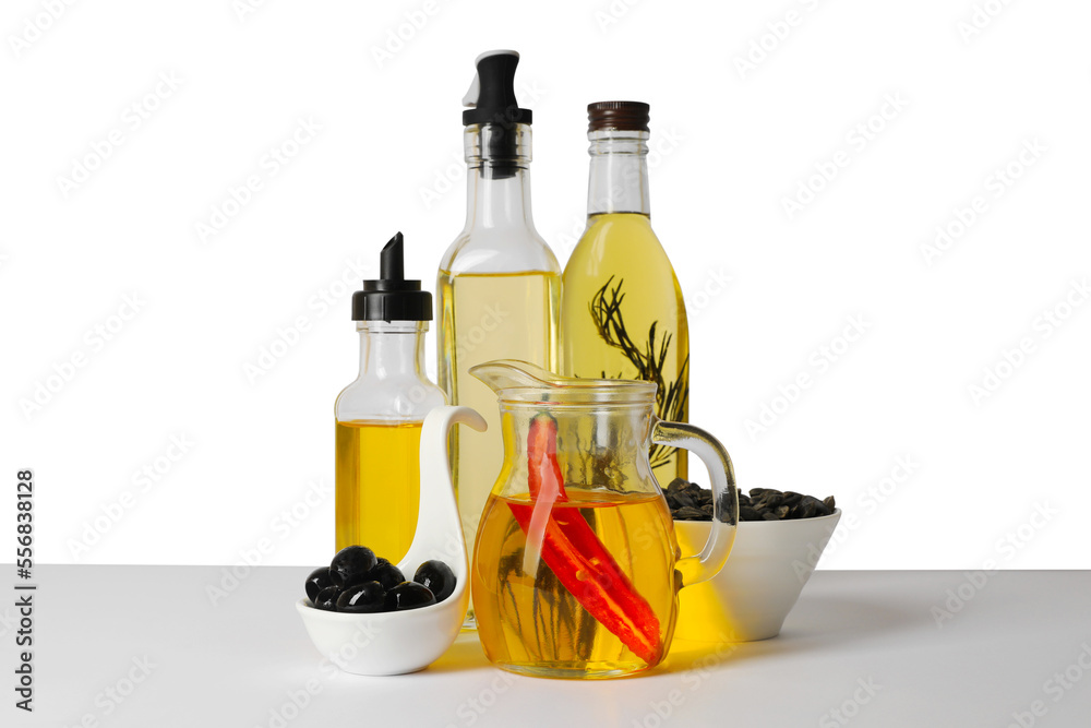 Bottles of different cooking oils, olives and sunflower seeds on white background Bottles of different cooking oils, olives and sunflower seeds on white background