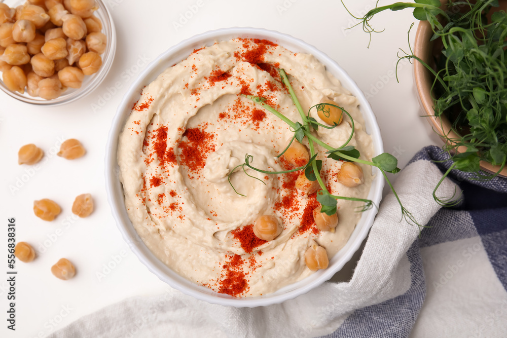 Delicious hummus with chickpeas and paprika served on white table, flat lay Delicious hummus with chickpeas and paprika served on white table, flat lay