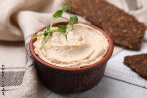 Delicious hummus served on white wooden table, closeup