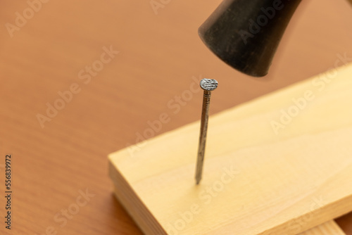 木板に釘を打つ