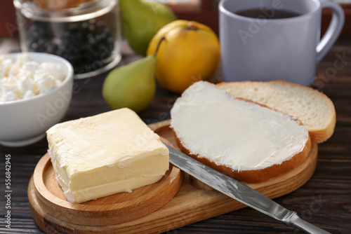 Tasty homemade butter, bread slices and tea on wooden table