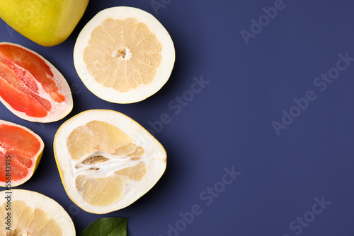 Fototapeta Naklejka Na Ścianę i Meble -  Different sorts of tasty pomelo fruits on dark blue background, flat lay. Space for text