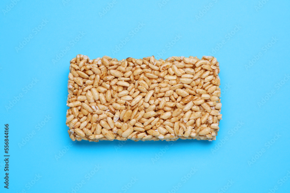 Puffed rice bar (kozinaki) on light blue background, top view Puffed rice bar (kozinaki) on light blue background, top view