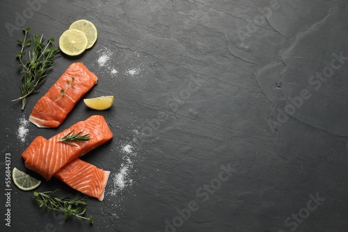 Fresh salmon and ingredients for marinade on black table, flat lay. Space for text
