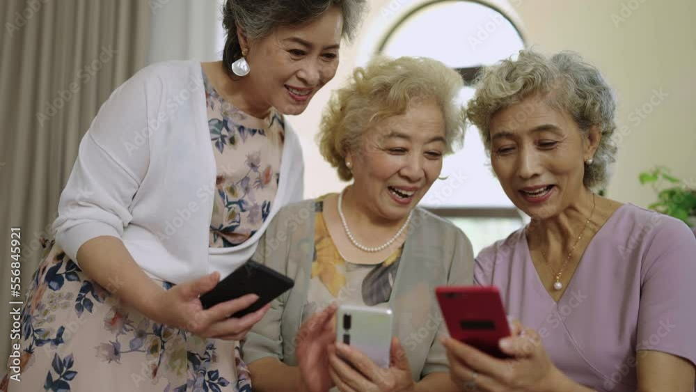Happy senior friends using smart phones at home,4K