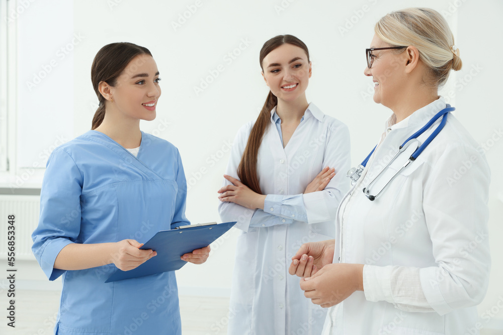 Medical doctors in uniforms having discussion indoors Medical doctors in uniforms having discussion indoors