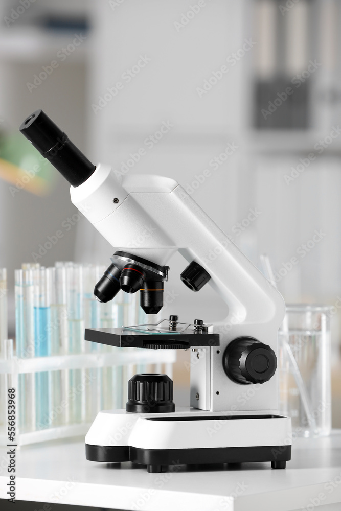 Modern medical microscope on white table in laboratory Modern medical microscope on white table in laboratory