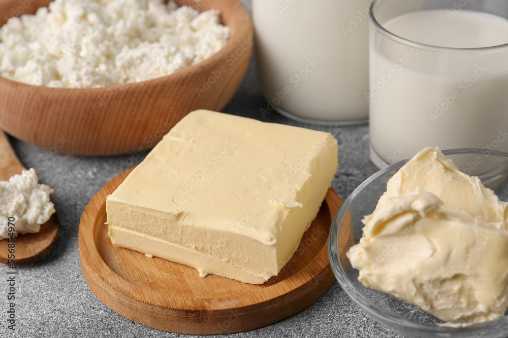 Piece of tasty homemade butter and dairy products on grey table