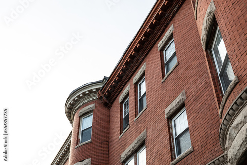 Oblique view of brick apartment building with rusticated stone window lintels  and dentil trim details, horizontal aspect
