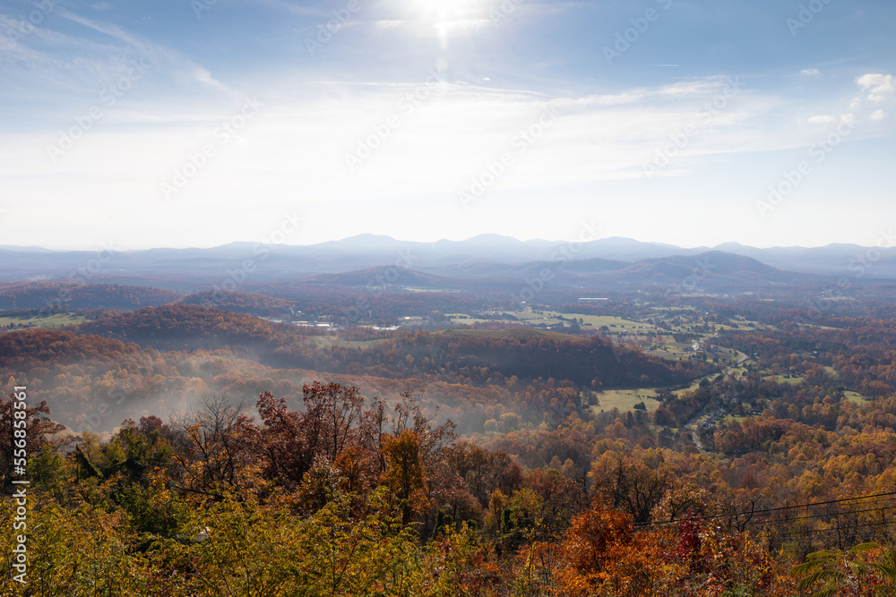 Scenic overlook of mountains with bright sun burning off ground fog, eastern USA, horizontal aspect