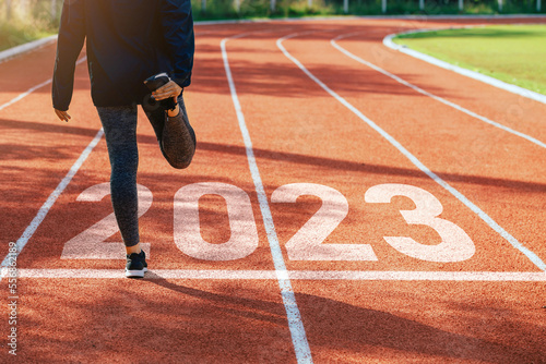 Starting to the new year 2023. Woman a runner waiting to start the new year 2023.Planning, opportunity, challenge, and business strategy. Goals, plans, and Adopt for Success in 2023 for new life.