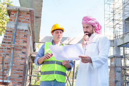 Arabic businessman teammates working together, construction engineer architect and worker looking building model and blueprint blueprint plans of Arab businessman.