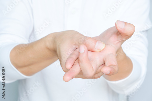 Man's hand. He massaged his hand and had finger pain. Locked fingers from work and office syndrome on a white background medical concept