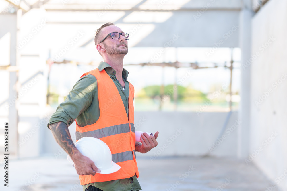 Handsome engineer man and architect working at construction site with calculate spending report inside house. Real Estate Project with Civil Engineer