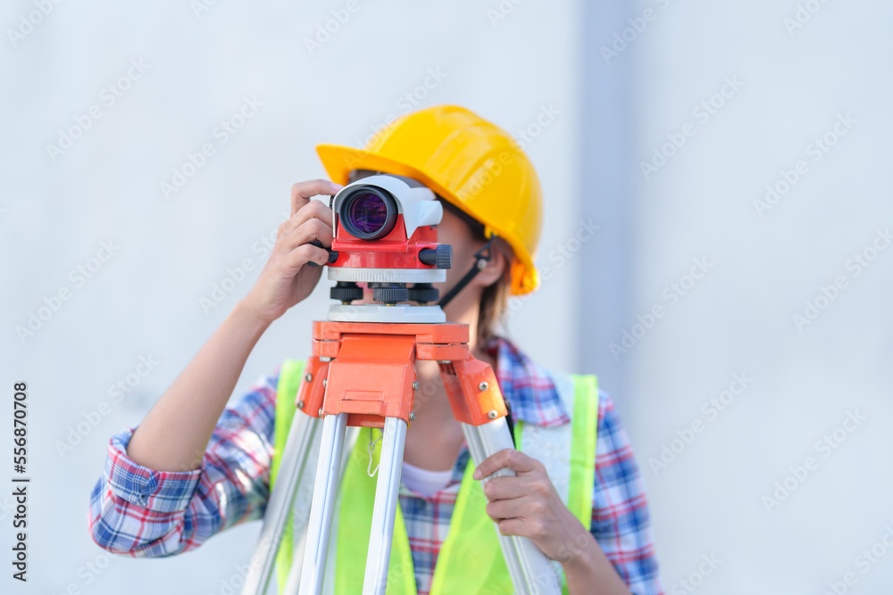 Female survey working Using Theodolite Surveying Optical Instrument for Measuring Angles in Horizontal and Vertical Planes on Construction Site.