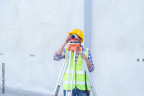 Female survey working Using Theodolite Surveying Optical Instrument for Measuring Angles in Horizontal and Vertical Planes on Construction Site.