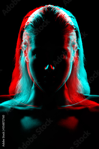 Foto Studio portrait of woman silhouette with long hair and bright blouse in red and blue color split effect