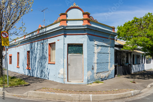 A brightly coloured historic house on a suburban street corner photo