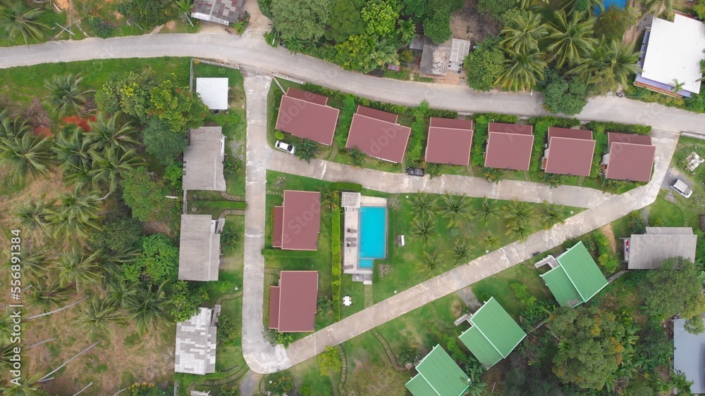 Cinematic view from drone to resort with pool and small houses in tropical jungle of Thailand. Drone view of family vacation hotel. Wintering in the tropical countries of Asia. Life on Koh Phangan