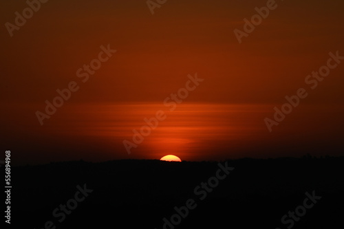 Silhouette image of a hill. Image of a Sunset behind the hill