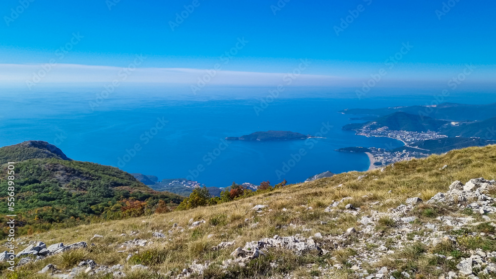 Panoramic aerial view on the coastline of Budva and Sveti Nikola Island seen from Goli Vrh, Adriatic Mediterranean Sea, Montenegro, Balkan, Europe. Luxury hotel resorts along Budvanian Riviera.