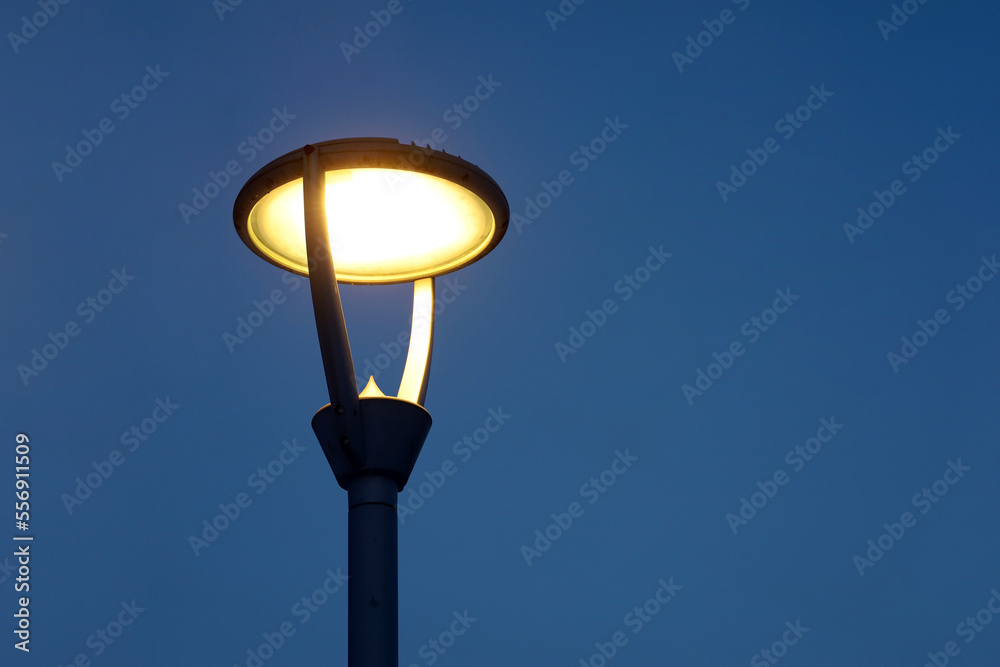 Glowing led lamp on evening sky background. Electric lighting, energy-saving street lantern Glowing led lamp on evening sky background. Electric lighting, energy-saving street lantern