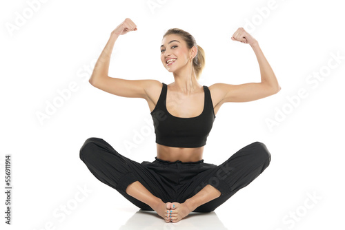 young sitting happy woman in sport clothes on white background