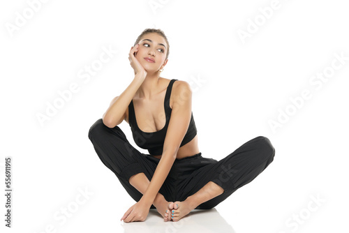 young sitting smiling woman in sport clothes on white background