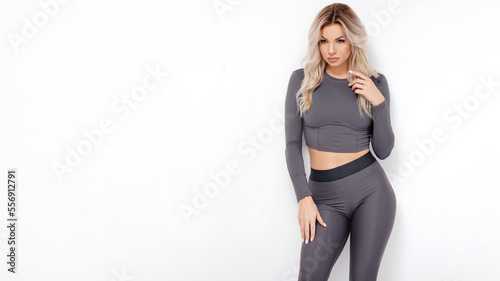 Portrait of young fitness woman in sportswear posing