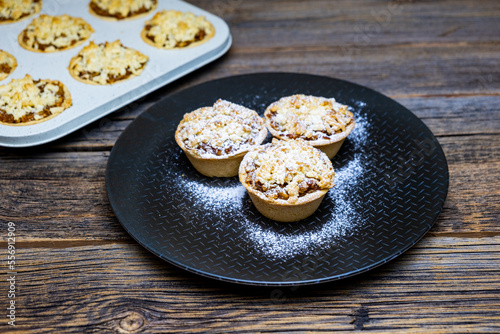 Homemade apple pies, mini apple pies on rustic wooden background, close-up.