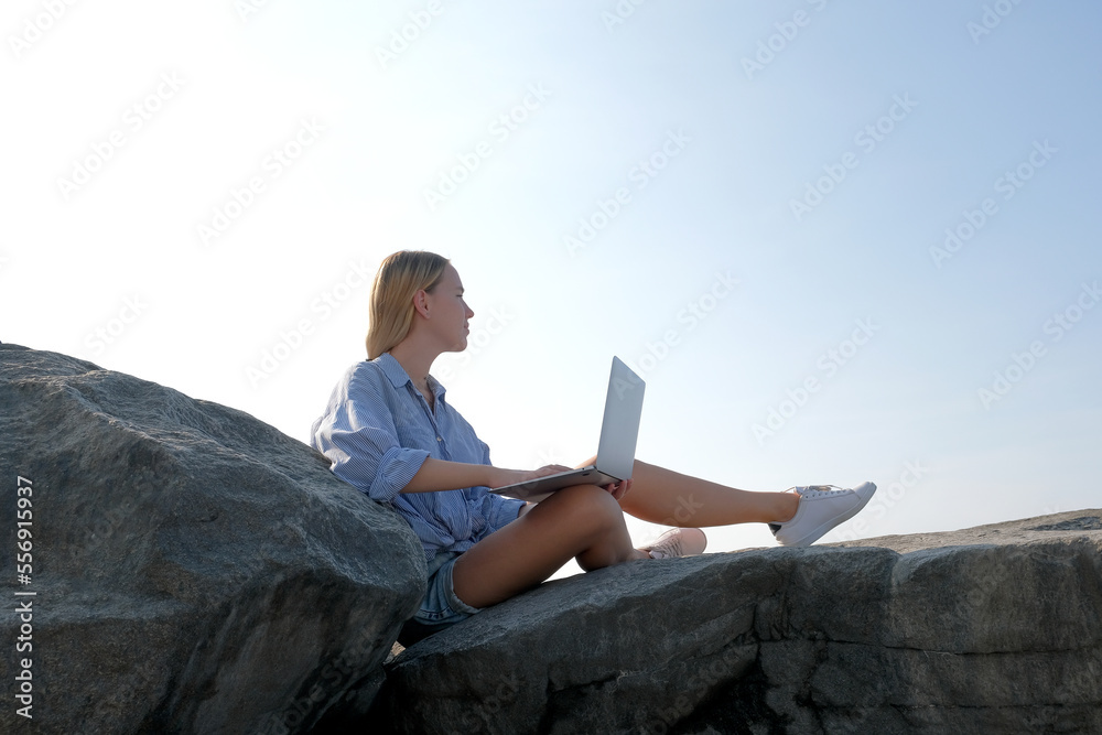 Remote work.Girl freelancer works remotely on the sea shore. workation, remote work,WFVH,Van Life vibes work from vacation home,work travel,remotely work.Travelling.Work from vacation remotely