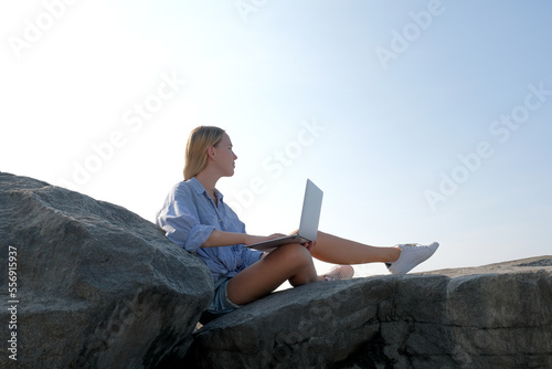 Remote work.Girl freelancer works remotely on the sea shore. workation, remote work,WFVH,Van Life vibes work from vacation home,work travel,remotely work.Travelling.Work from vacation remotely