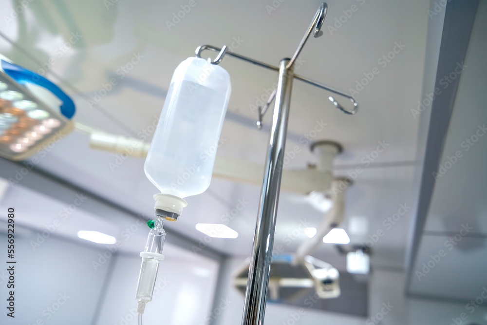 Intravenous or Iv fluids drip bottle hanging on a metal pole in