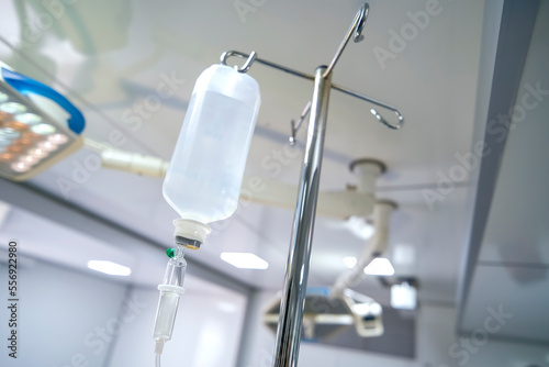 Intravenous or Iv fluids drip bottle hanging on a metal pole in hospital emergency room. Equipment and medical devices.