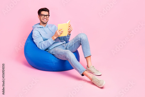 Photo of smart clever guy sitting home relax rest comfort bag like read fiction genre empty space isolated on pink color background