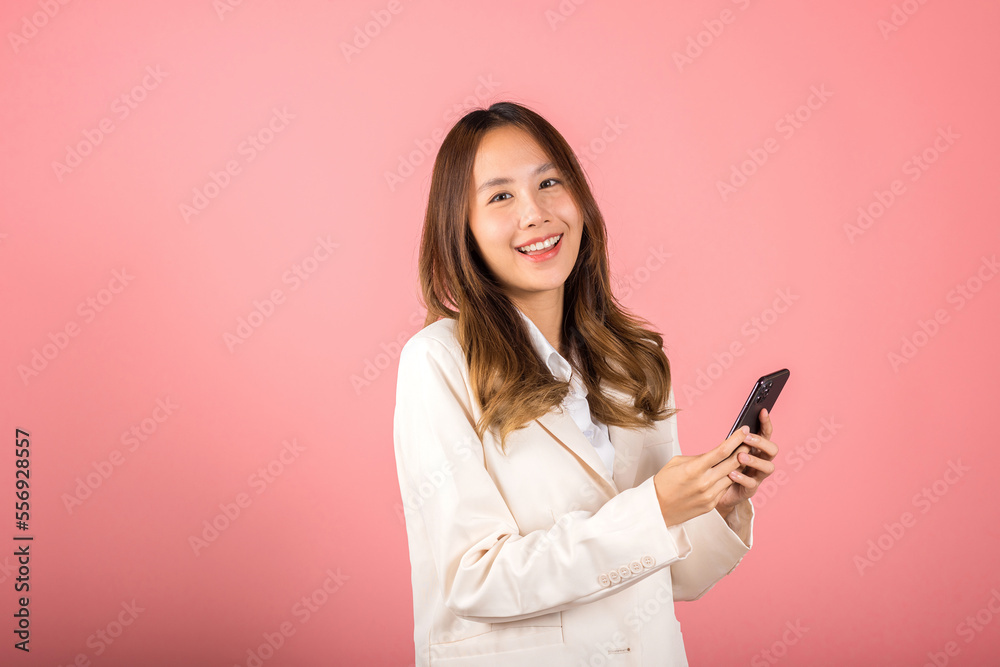 Female surprised and sms chatting internet online on smartphone studio shot isolated on pink background, Happy Asian portrait beautiful cute young woman teen smiling excited hold smart mobile phone