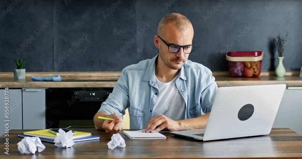 Man struggles with writing plan and analysing necessary information for business project. Freelancer tries to work out with detail plan and tears paper Man struggles with writing plan and analysing necessary information for business project. Freelancer tries to work out with detail plan and tears paper