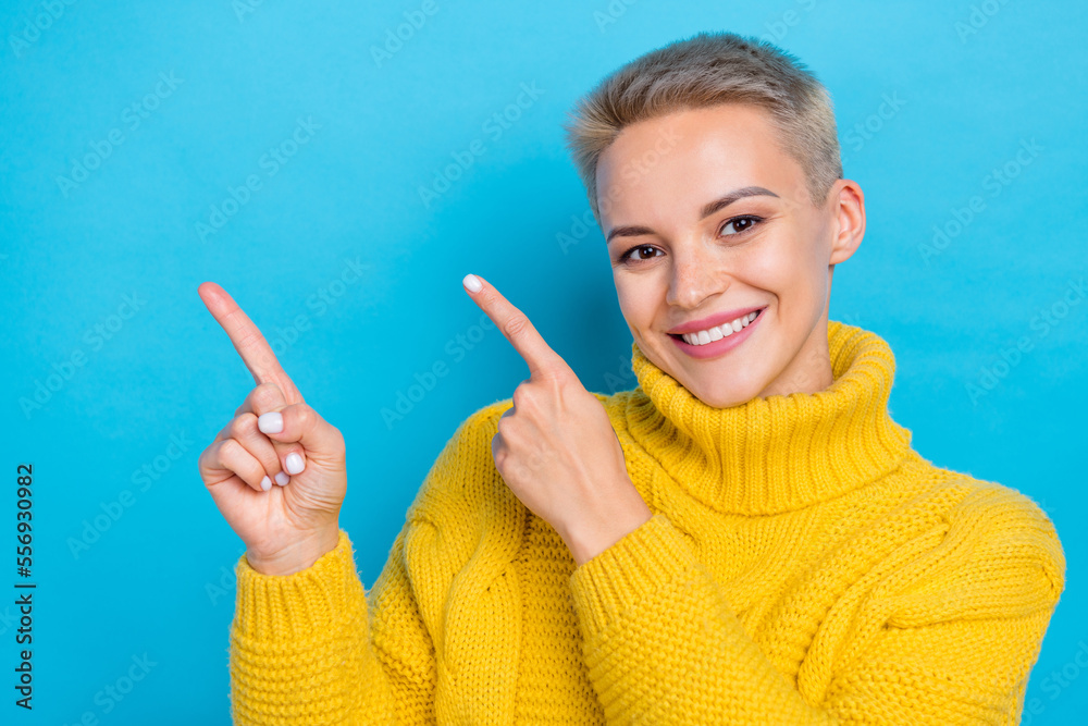 Photo of shiny charming lady wear knit sweater pointing two fingers empty space isolated blue color background