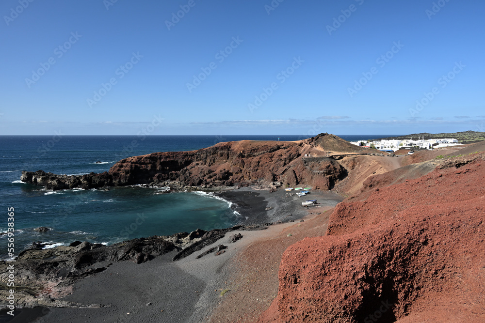 Das kleine ursprüngliche Fischerdorf El Golfo, an der Küste der Kanareninsel von Lanzarote bei strahlend blauem Himmel und Sonnenschein