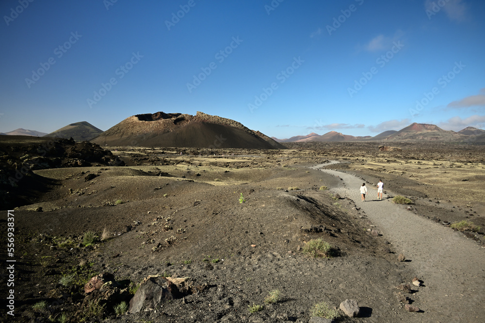 Menschen Wandern auf der Kanareninsel Lanzarote bei blauem Himmel zum Vulkan Es Cuervo 