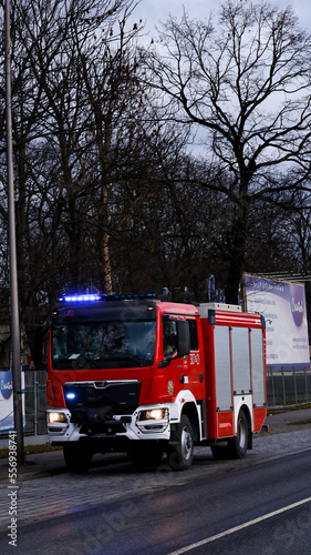 wóz strażacki stojący na poboczu jezdni gotowy do akcji 